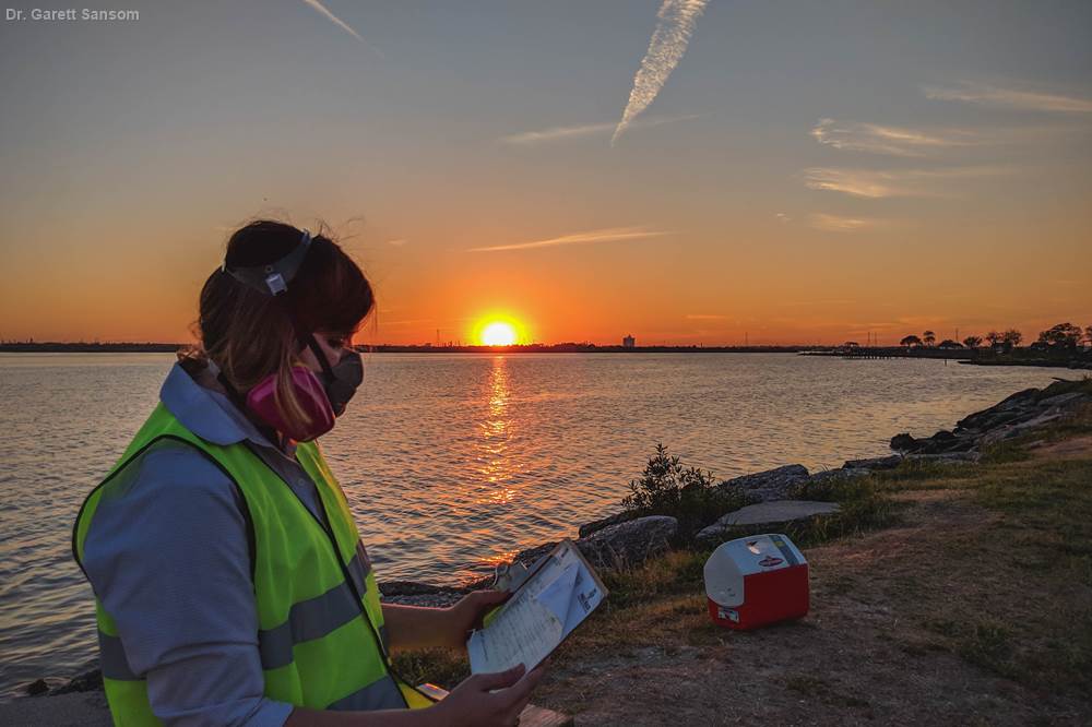 Public health master’s student, Kathleen Aarvig, wears a protective mask while collecting air and water samples following the ITC petrochemical plant fire. 